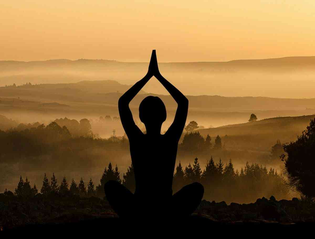 Woman in yoga pose with sunset peaceful