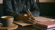 Write for the Ability Toolbox. Image: African-American woman writing in notebook.