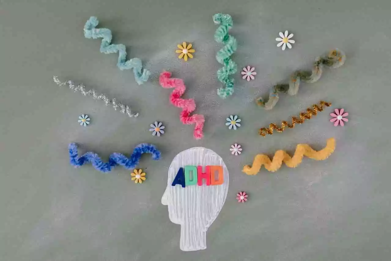 New adult ADHD diagnosis: what to do. Collage of bendy pipe cleaners emanating from a head with the letters ADHD.