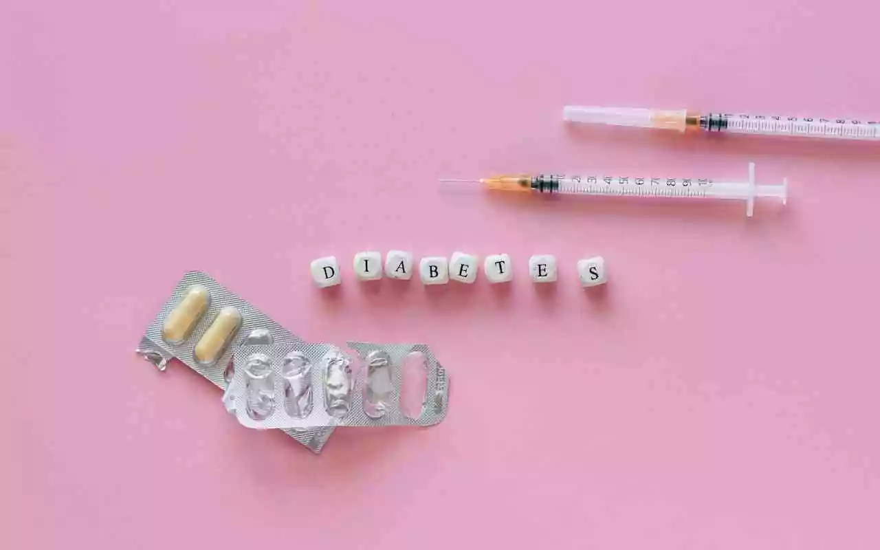 Managing type 2 diabetes: syringes and pills surround block lettering.