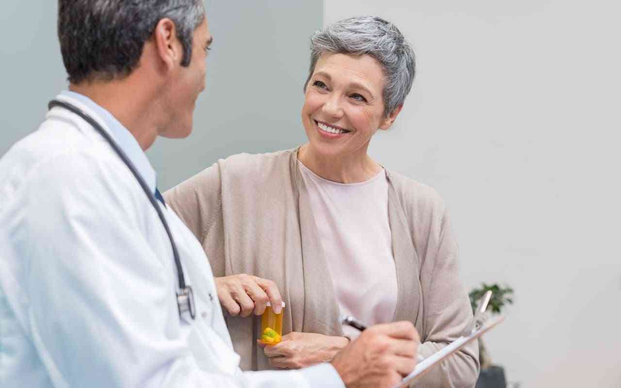 Maintaining bone health during menopause. Woman talking to doctor.