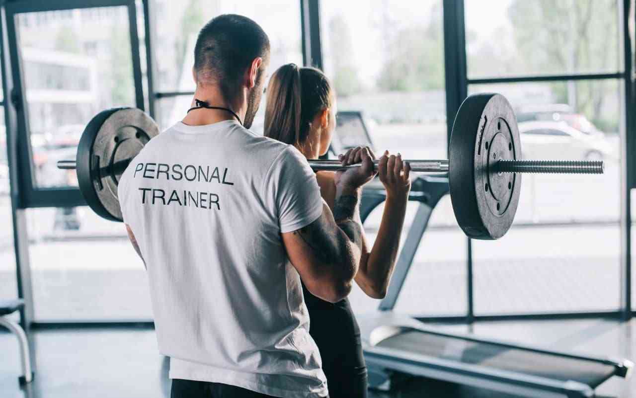 Personal trainer assisting client.