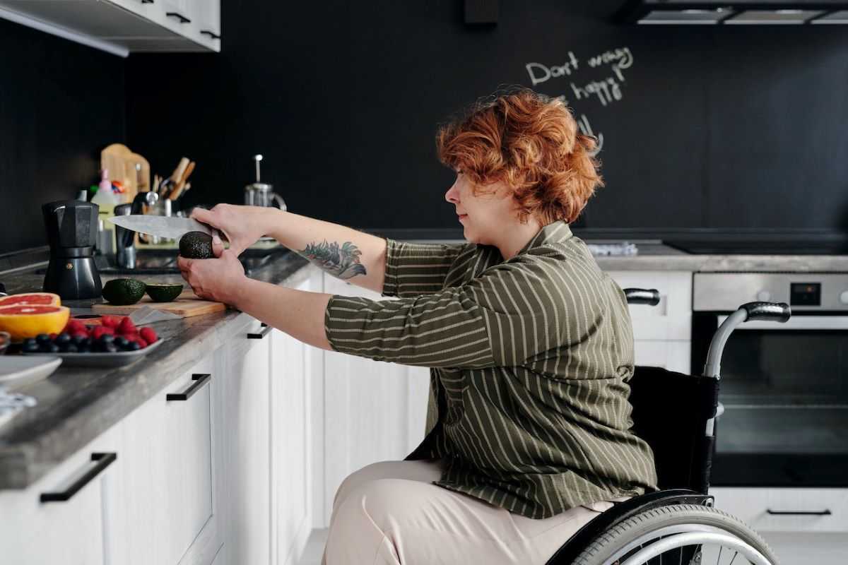 Woman in wheelchair cooking in the kitchen.