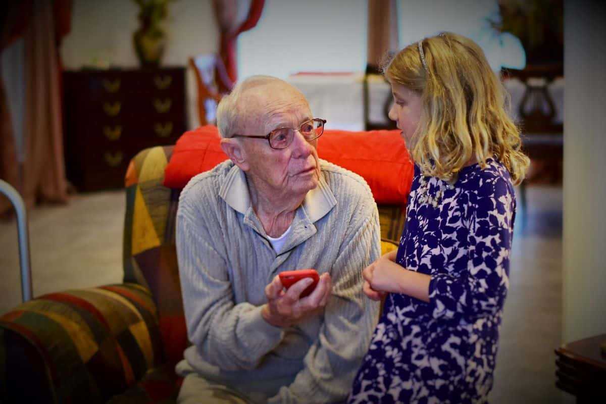 Elderly man playing with granddaughter.