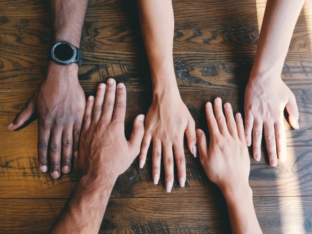 Hands on table symbolizing peer support at work.