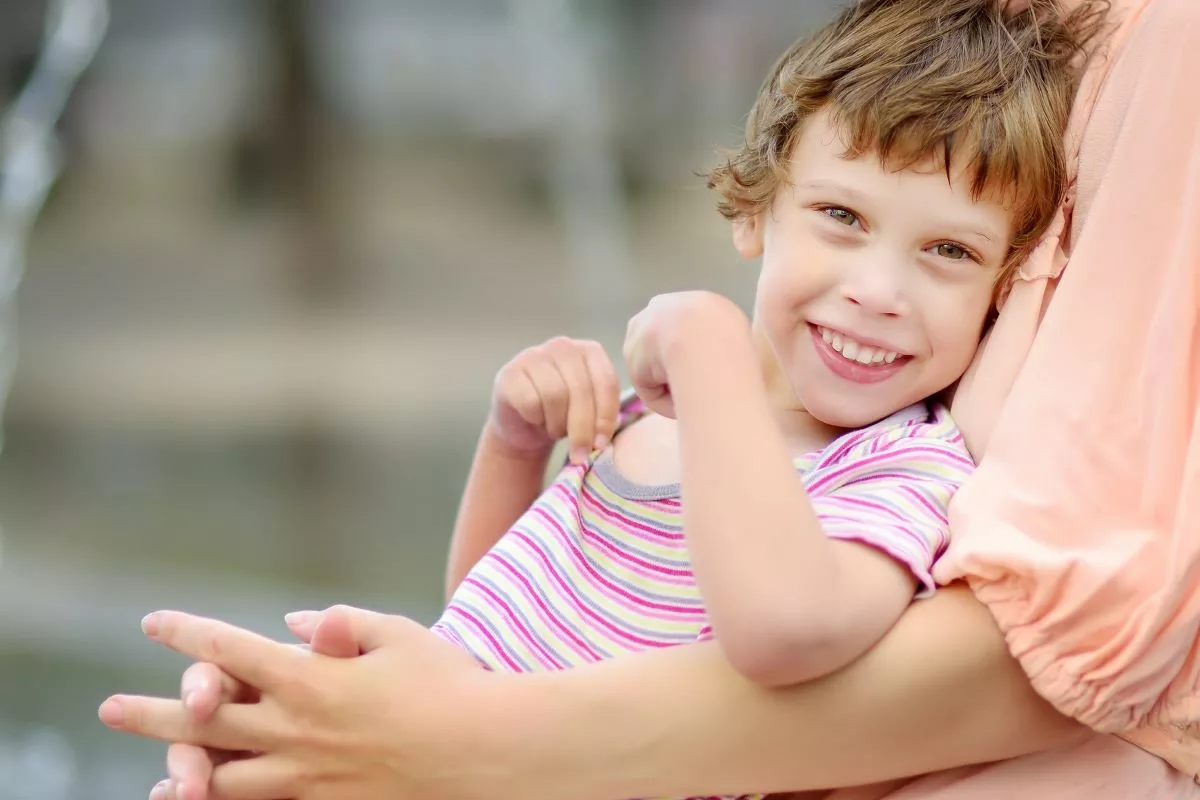 Parent hugging child with cerebral palsy.