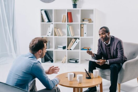 Man talking to psychiatrist in intensive outpatient program for mental health treatment.
