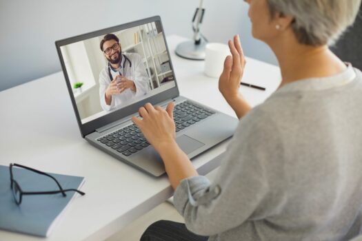 Woman meeting with doctor via telehealth.