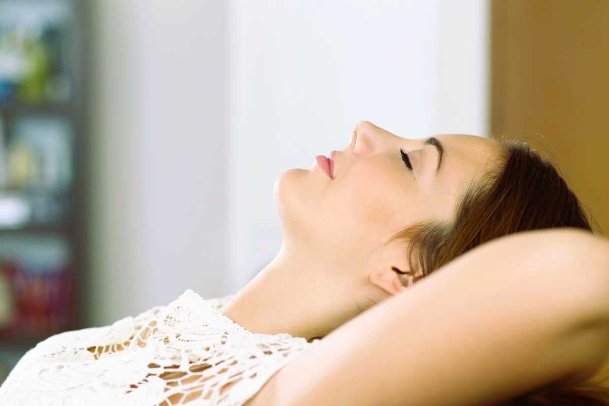 How to reduce anxiety. Woman relaxing on sofa.