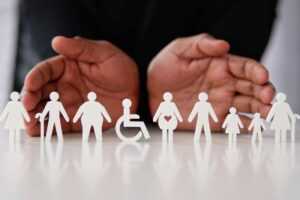 Disability inclusion: paper cutouts representing disabled people of different ages and body types including a wheelchair.
