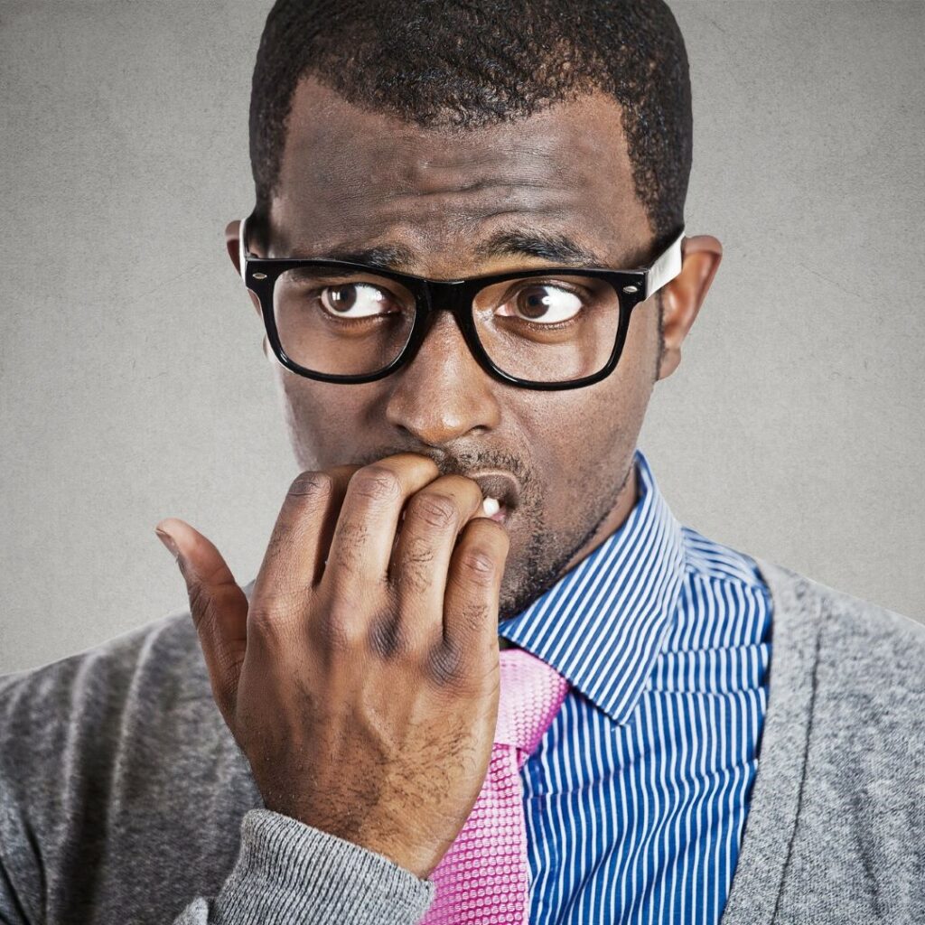 What autism feels like in social situations. Nervous Black man with glasses wearing a tie.