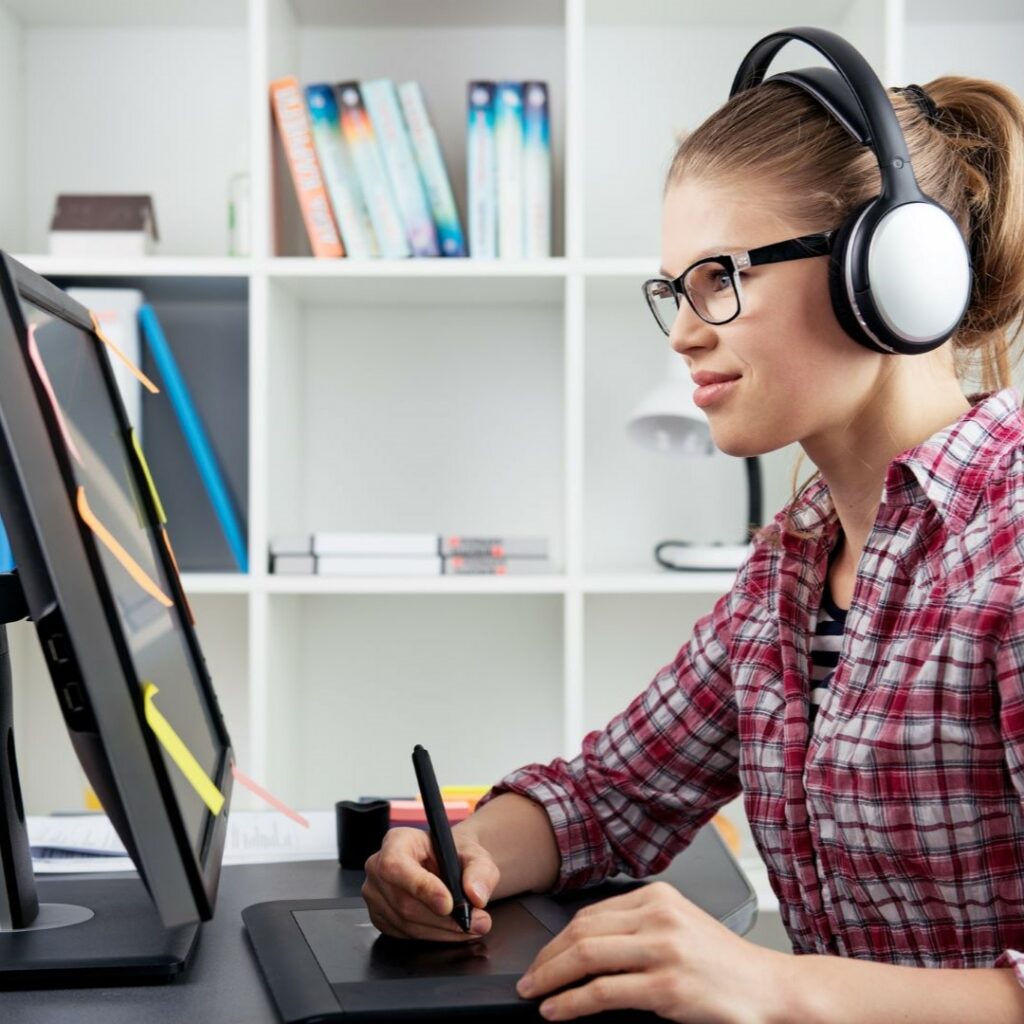 Autistic person using headphones while working on a computer.