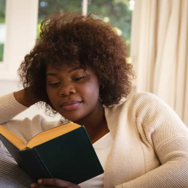 Woman reading a novel in which a character lives with mental illness.