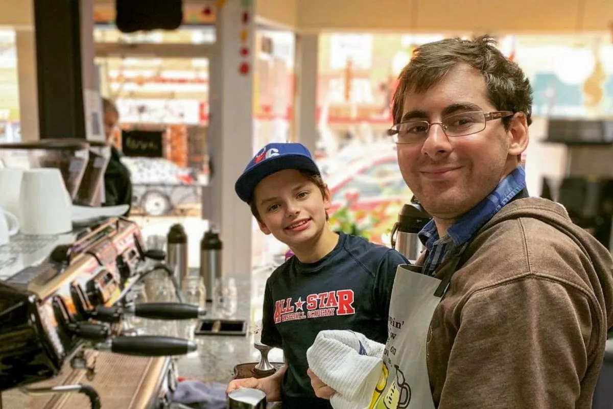 A teen boy and adult man working behind the counter at the GET Cafe coffee shop in Narberth, PA.