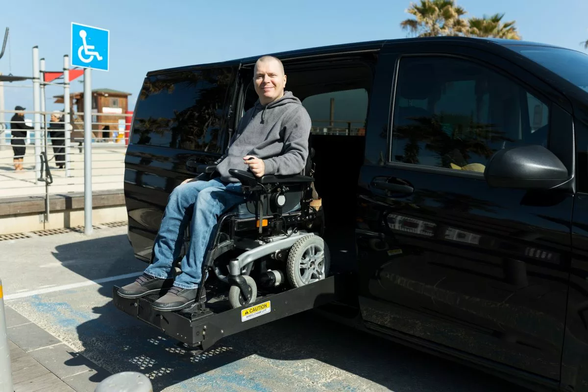 Man in power wheelchair sitting on a van lift.