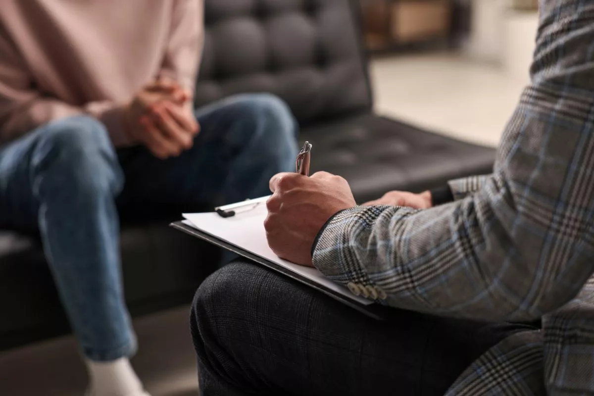 Therapist taking notes during session with patient.