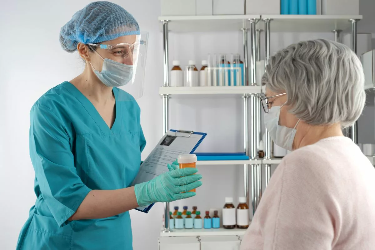 Nurse dispensing medication to patient.