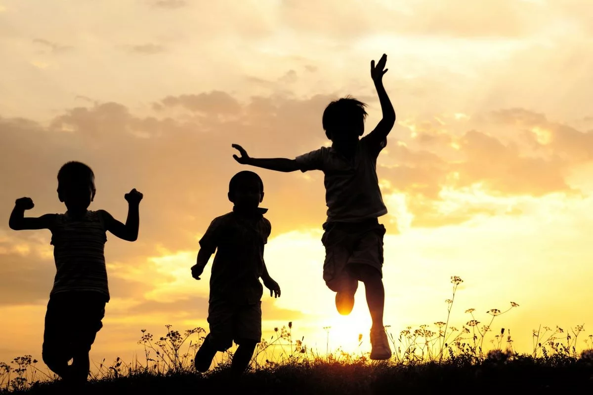 Children playing outdoors at sunset.