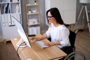 Woman in wheelchair studying at computer.