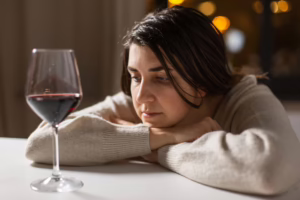 Woman looking at a glass of wine.