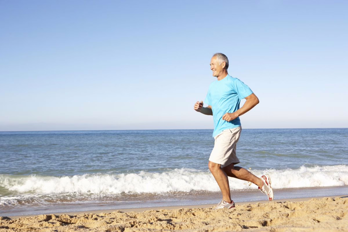 Older man running by the beach.