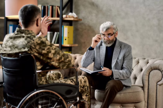 Veteran in wheelchair talking to therapist.