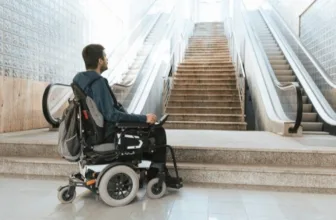 Man in wheelchair looking at stairs.