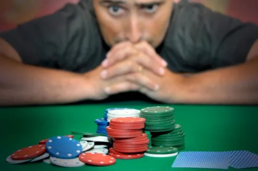 Stressed man looking at poker chips.