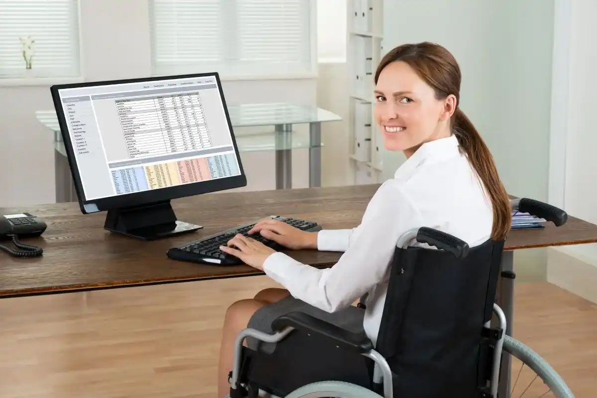 Woman in wheelchair working on computer.