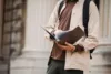 Student looking through a book of scholarships.