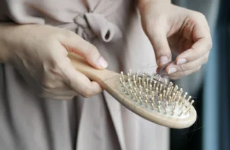 Woman picking hair from a brush.