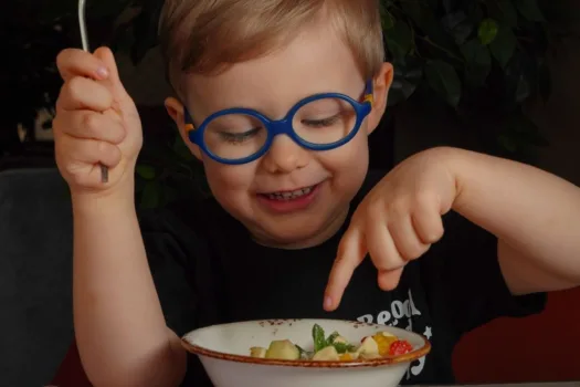 Child with glasses eating.