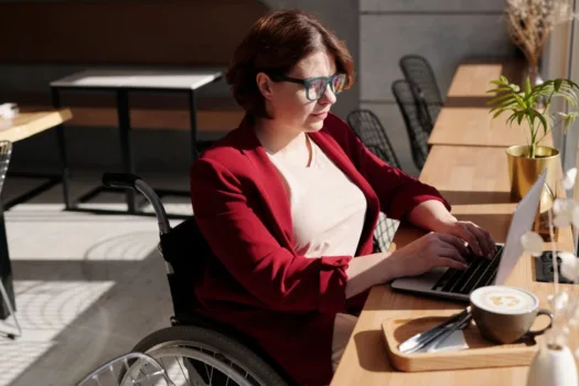 Woman in wheelchair using computer.