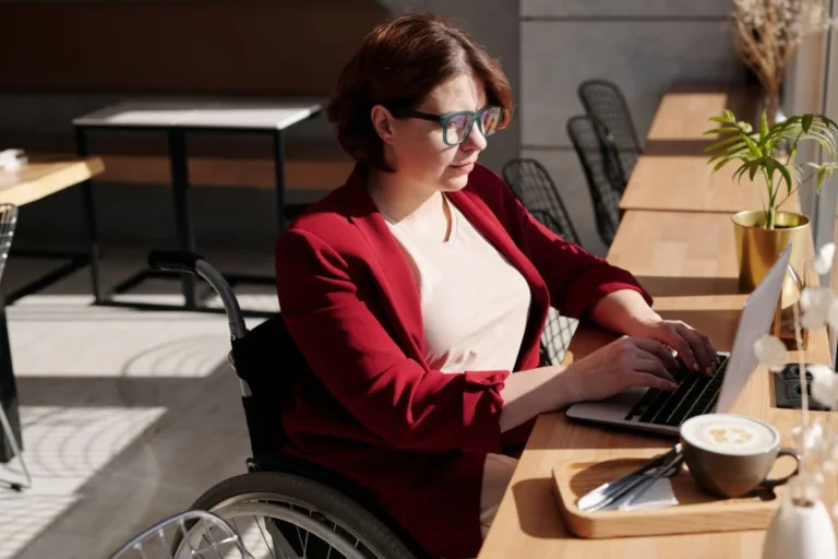 Woman in wheelchair using computer.