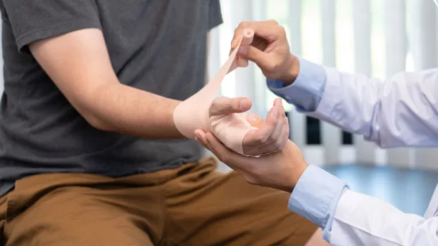 Doctor examining patient's injured hand.